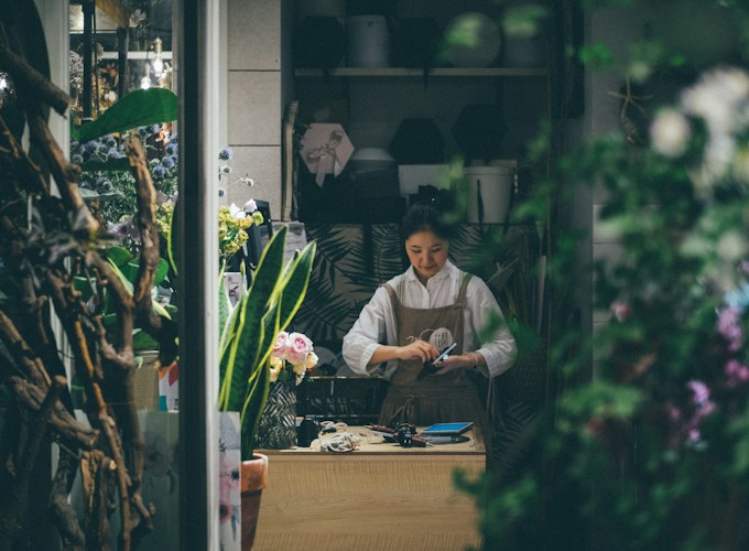 Frisco florist arranging stock in her shop, one of the small businesses Creekfield Lenders serves